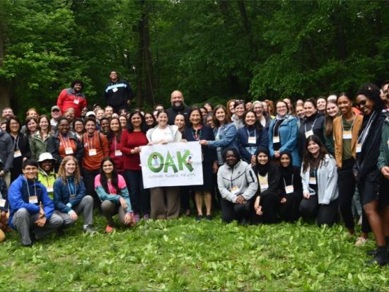 Secretary Haaland poses outdoors with a large group of high school students