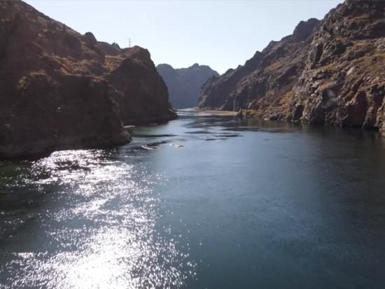 Aerial view of Colorado River flowing between steep rocky embankments