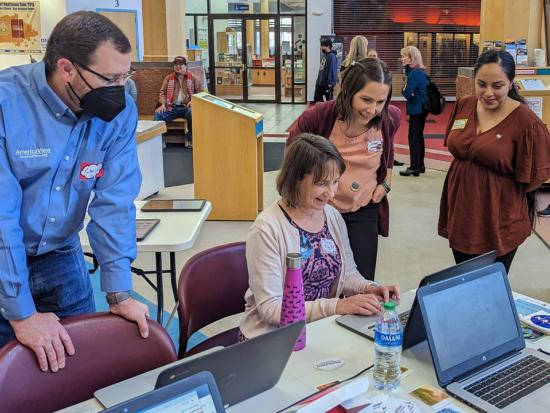 Assistant Secretary for Water and Science Tanya Trujillo sits at a desk and uses a laptop to create Landsat artwork