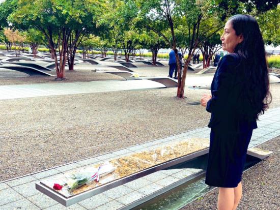 Secretary Haaland stands beside a memorial bench at the Pentagon 9/11 Memorial 