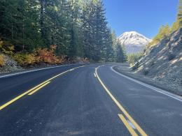 Paved road with a snowy mountain in the background