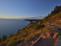 Wooden boardwalk path following hilly scenic lakeview trail. 