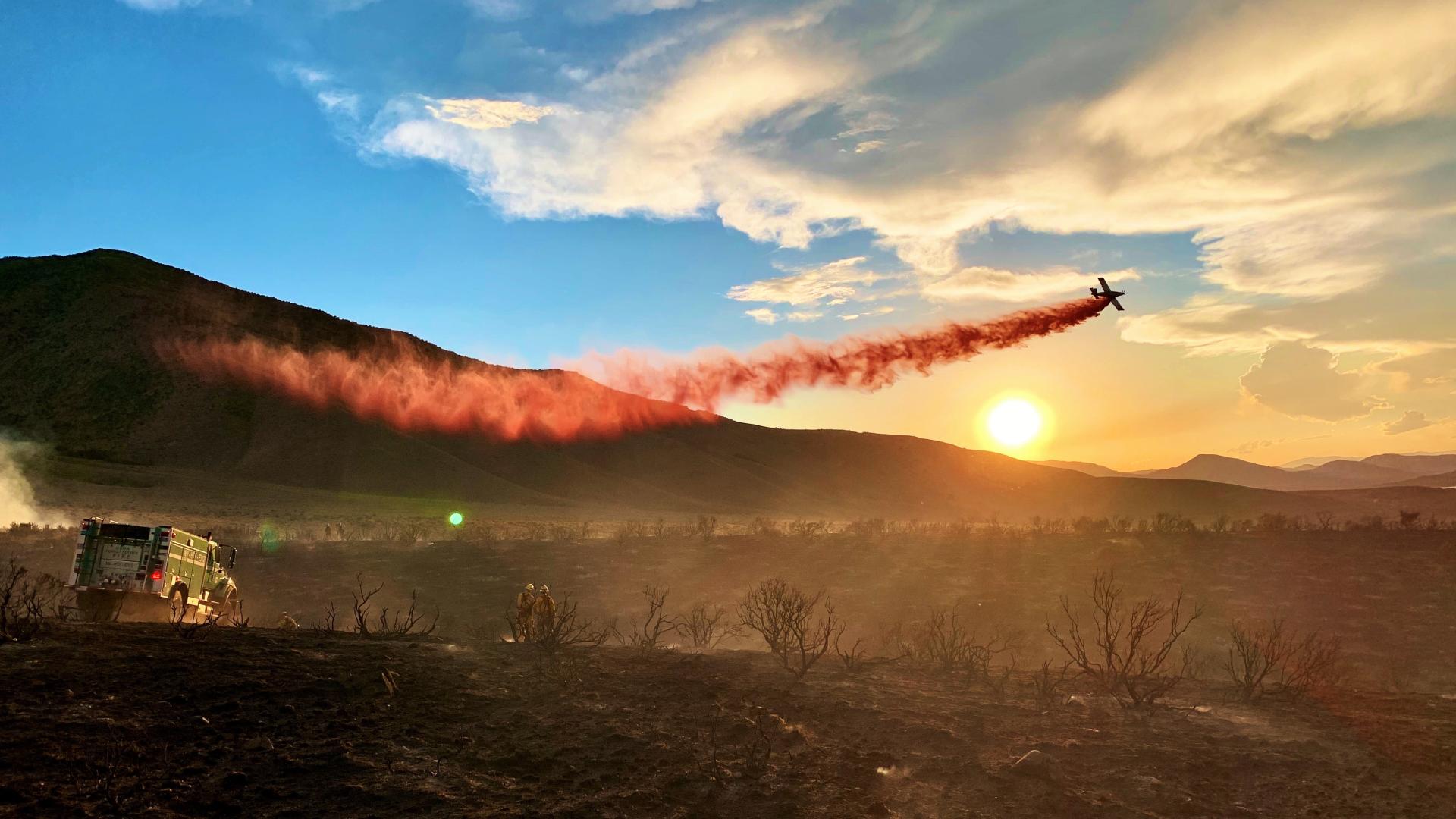 Firefighters watch a retardant drop on the Peavine Fire in Nevada at sunrise. Photo by Sarah McNeil, BLM.