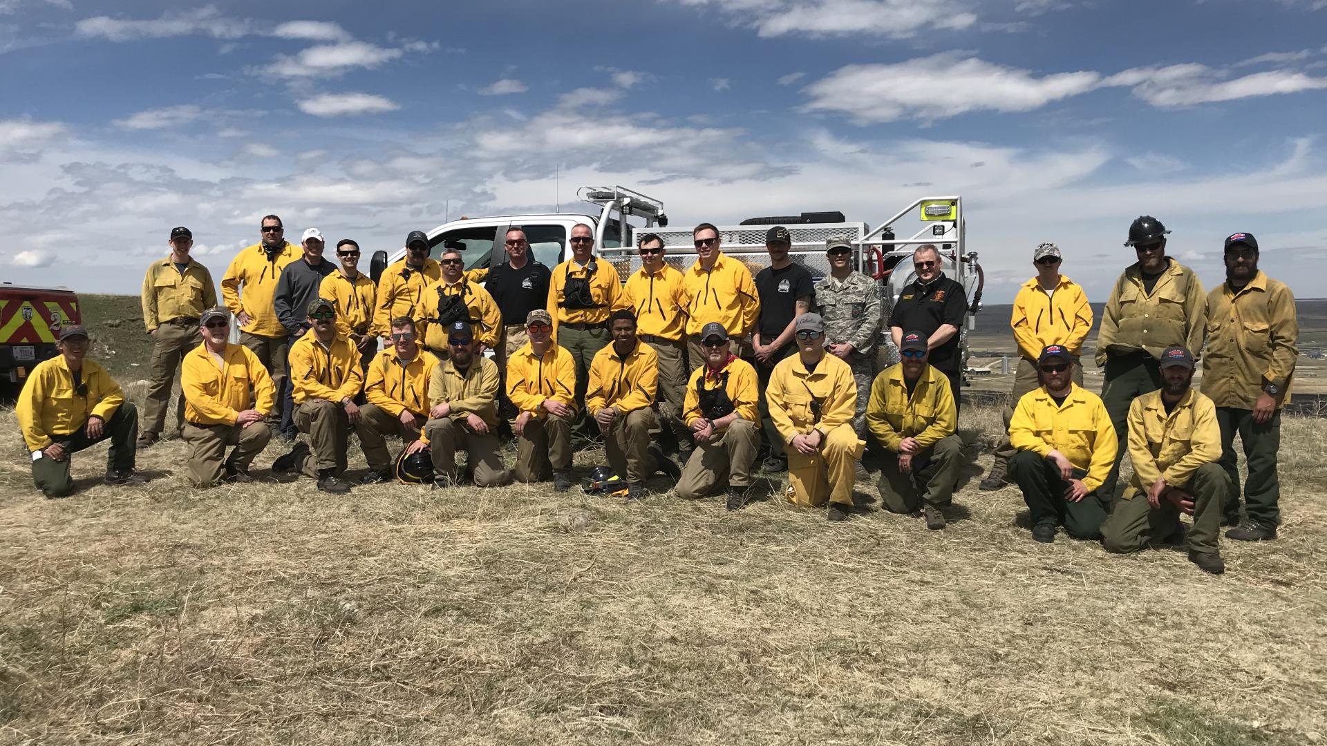 A group of firefighters standing in front of a fire truck