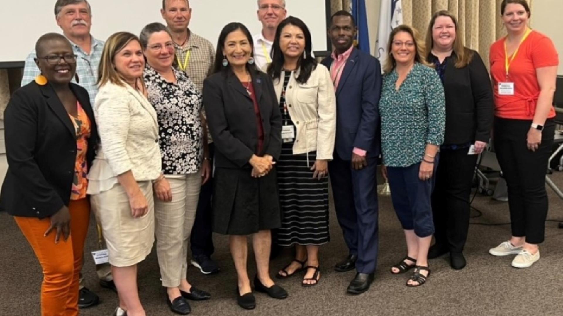 Shannon stands with her colleagues and coworkers as they pose for a photo with Secretary Haaland. 