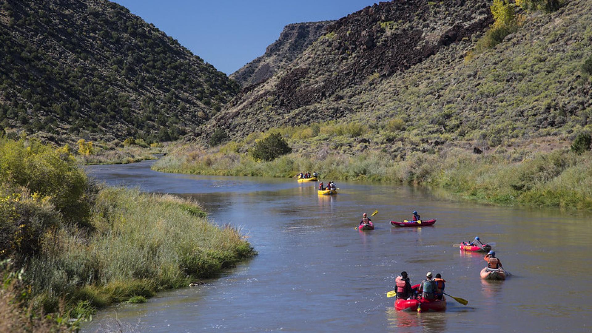 Kayakers paddle down the Rio Grande at Rio Grande del Norte National Monument