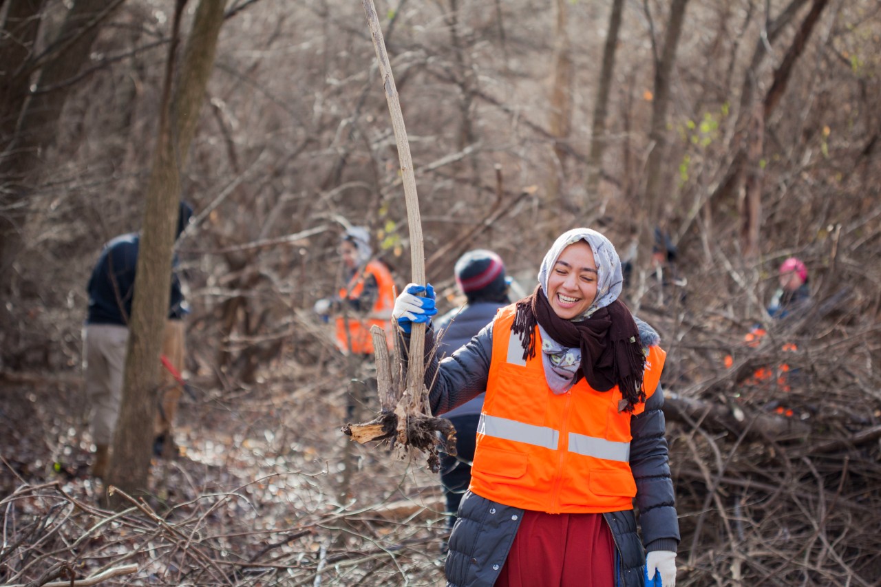 Several volunteers gather to pick up trash and remove invasive species in Anacostia Park.