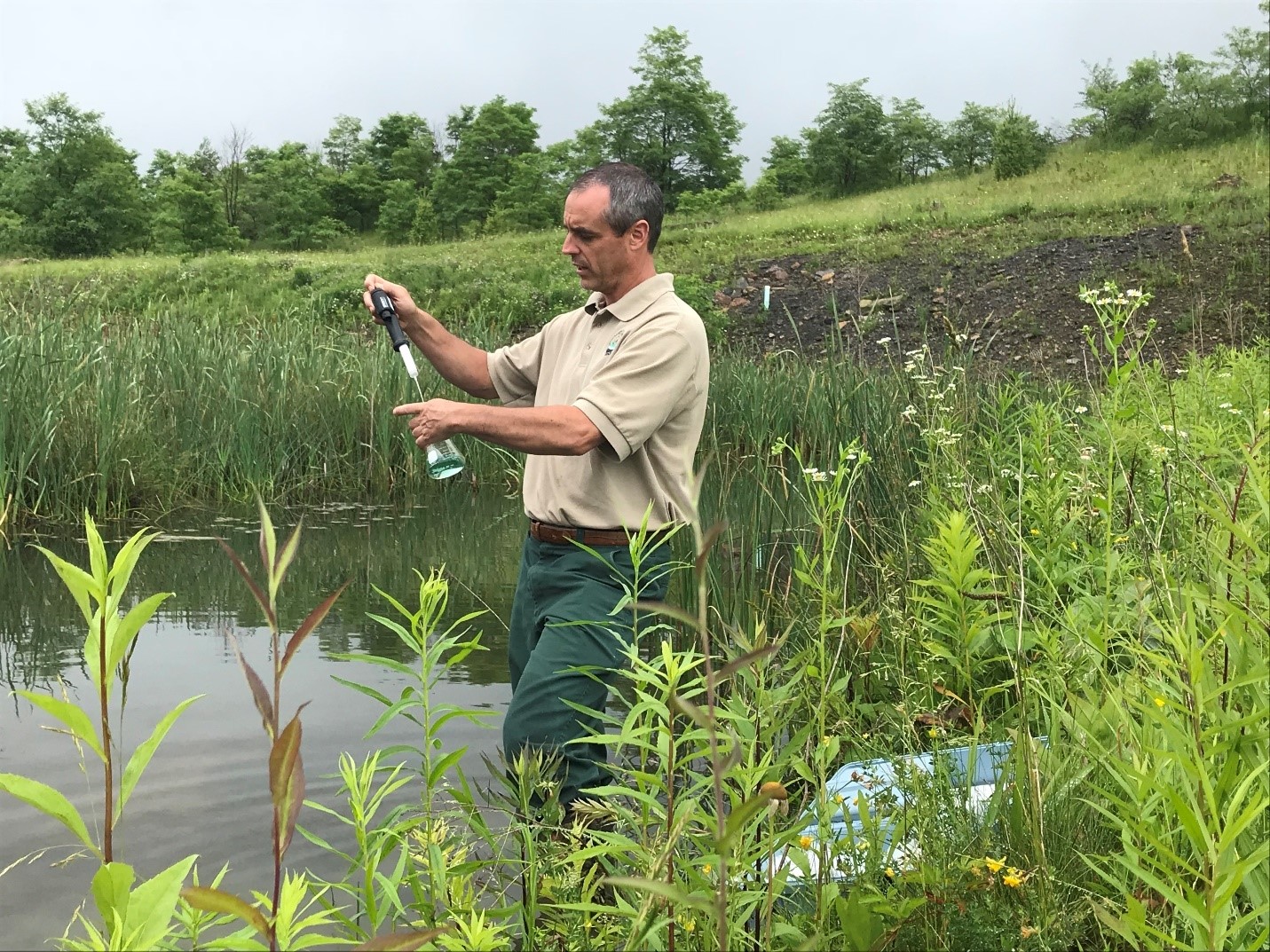 Brent Means takes a water sample.