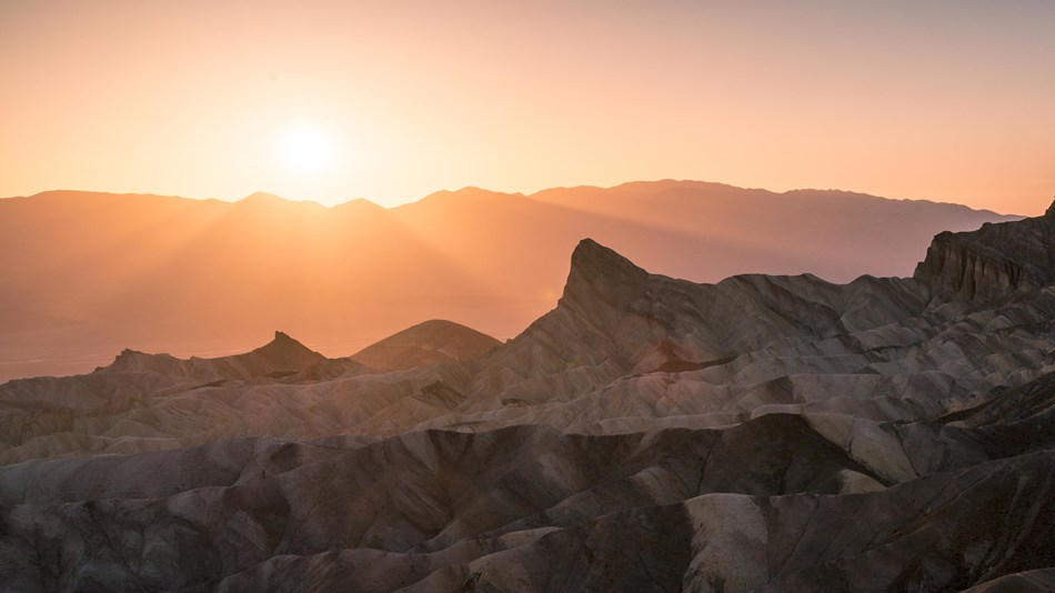 Rugged rock formations under a glowing sunset.