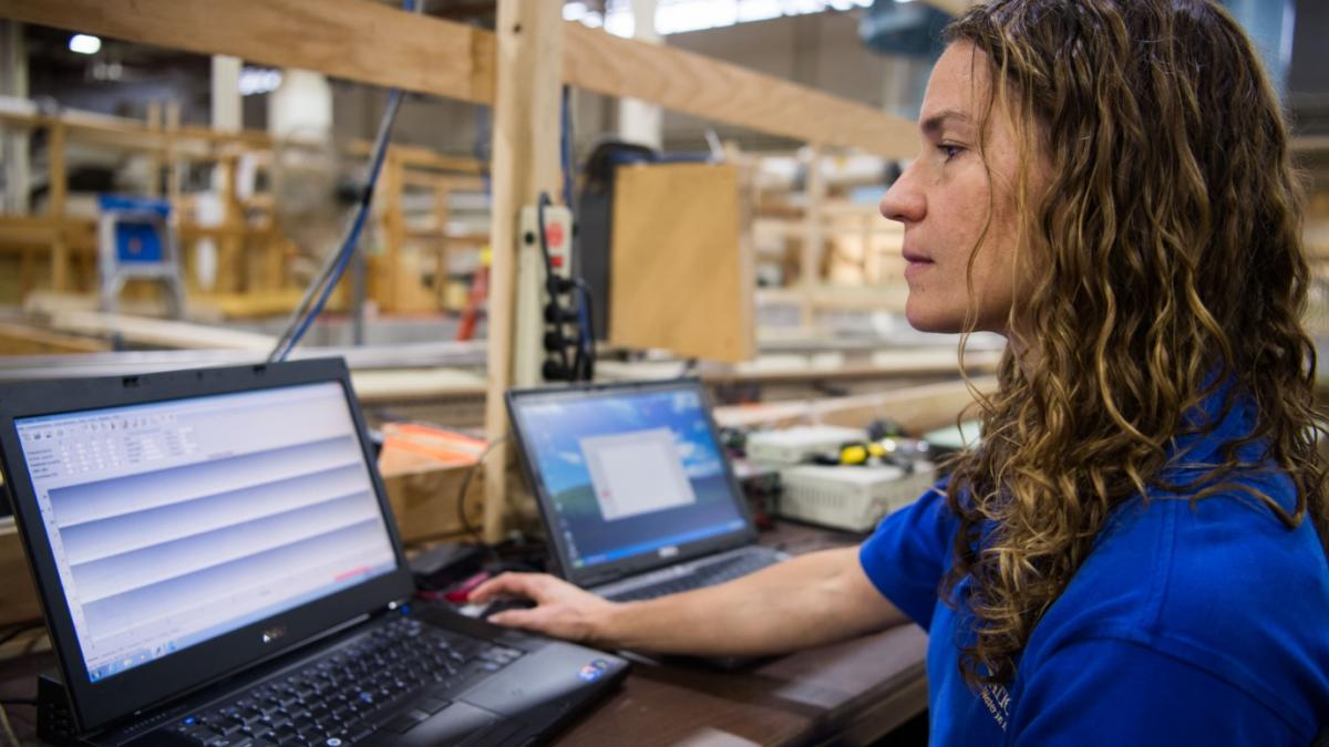 Woman engineer reviews data on a laptop.