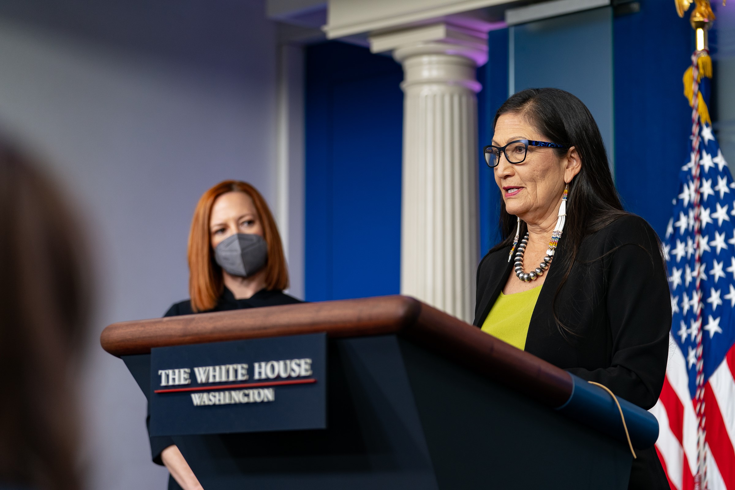 Secretary Haaland speaks at a podium next to White House Press Secretary.