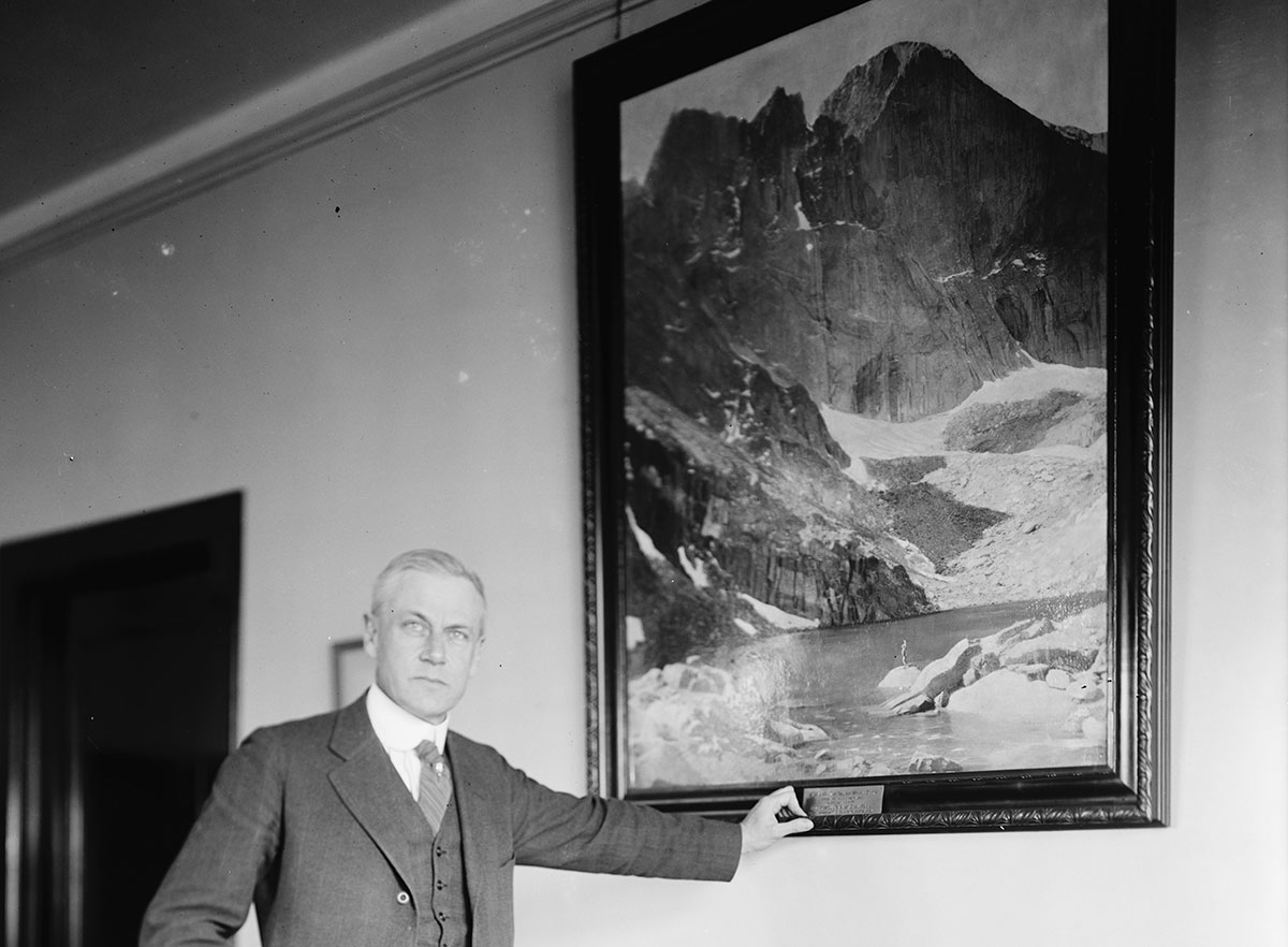 Stephen T. Mather standing by portrait.
