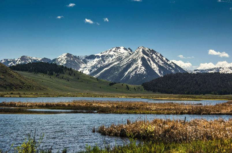 Snow covered mountain rising beyond a lake