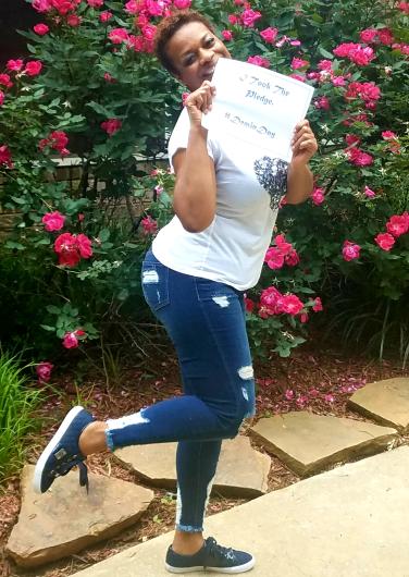 Acquanetta Reese from FWS outside, holding the I took the Pledge #DenimDay sign. 
