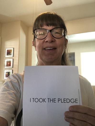 Patricia Aaron from USBR holding the I took the Pledge #DenimDay sign. 