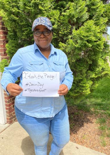 Acquanetta Newson from OCR, outside holding the I took the Pledge #DenimDay sign.