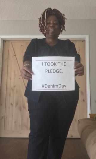 Alice Jenkins from OA holding the I took the Pledge #DenimDay sign.