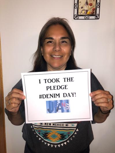 Anita Gonzales-Evans (OEA) holding the I Took the Pledge #DenimDay sign.