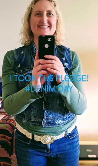 Alexandra Ritchie from BOEM with a denim jacket and jeans, standing doing a selfie, the I took the Pledge #DenimDay words written on the image. 