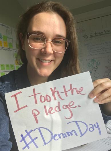 Ashley Dickerson from NPS holding a hand written I took the Pledge #DenimDay sign. 