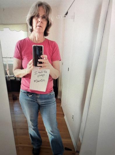 Barbara Little from NPS standing holding the I took the Pledge #DenimDay sign. 