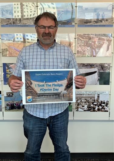 Brent Esplin from USBR holding the I took the Pledge #DenimDay sign. 