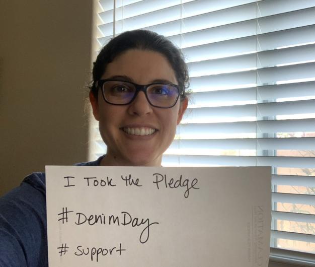Crystal Ponich (USBR)from FWS holding the I took the Pledge #DenimDay sign. At his back, wildlife set up exhibit item