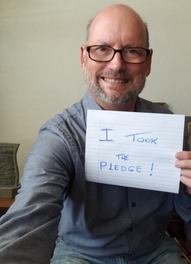 James Kirkland from USBR holding the I took the Pledge #DenimDay sign.