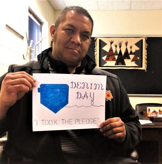 Leslie Shakespeare from BIA holding a hand written I took the Pledge #DenimDay sign