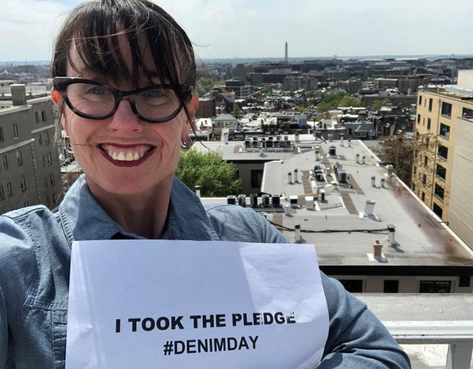 Tammy Ann Duchesne from PMB outside on top of the MIB's building, holding the I took the Pledge #DenimDay sign. 
