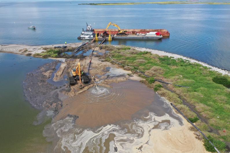 Placing sand on Queen Bess Island.