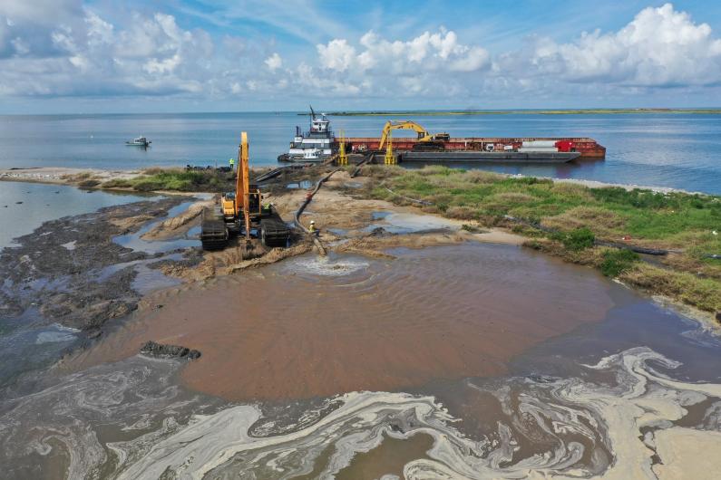 Placing sand on Queen Bess Island
