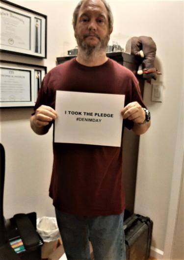 Eric Lindbloom from USGS holding the I took the Pledge #DenimDay sign. 