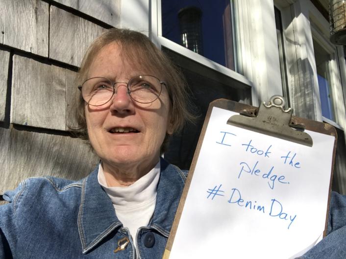 Fran Lightsom from USGS holding the I took the Pledge #DenimDay sign. At his back, wildlife set up exhibit item