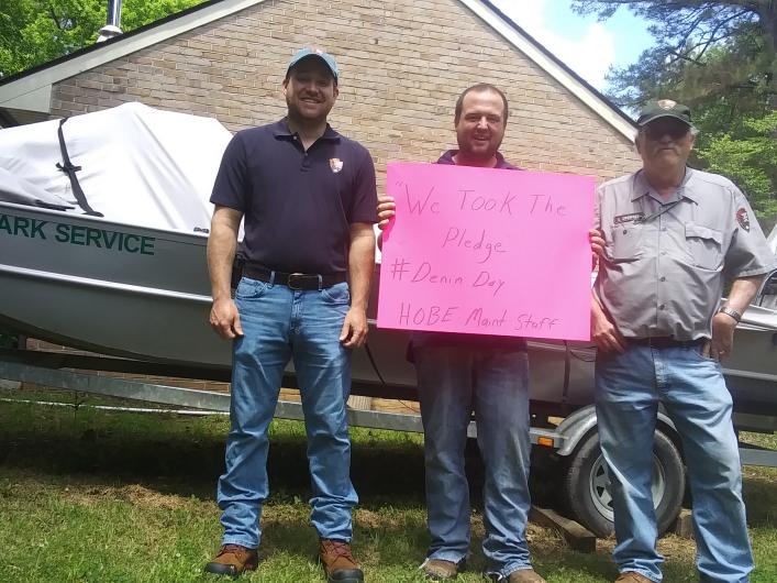Three employees from the NPS' Horseshoe Bend National Military Park (HOBE), standing outside with the We Took The Pledge" sign #DenimDay sign