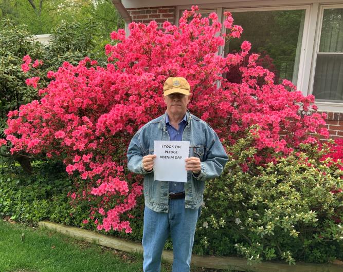 James Gallagher from OLE outside with the I Took The Pledge #DenimDay sign 