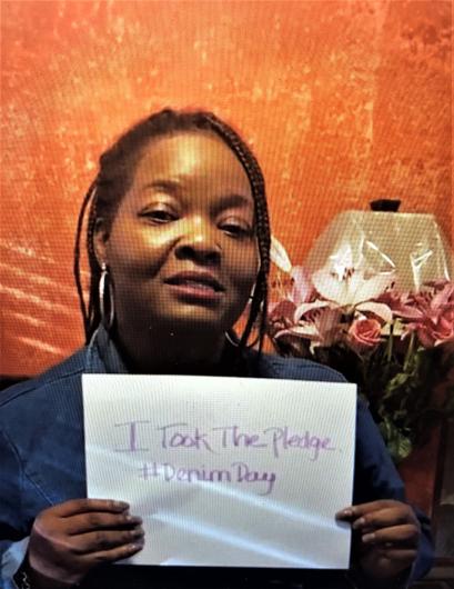 Erica White-Dunston from the DOI Office of Civil Rights (OCR) holding the I Took the Pledge #DenimDay sign.