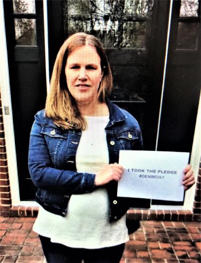 Lisa Branum from DOI holding the I took the Pledge #DenimDay sign. 