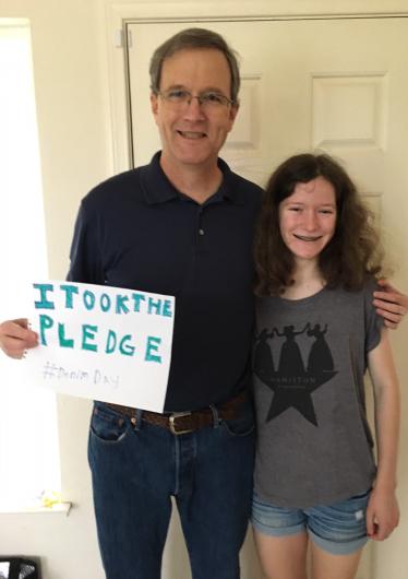John Payne from OHA, standing holding the I Took the Denim Day Pledge #DenimDay next to his daughter Laurel.  