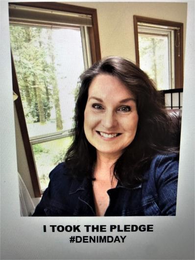 Kathy Hollar from FWS with the I took the Pledge #DenimDay words written on the image. At his back, wildlife set up exhibit item