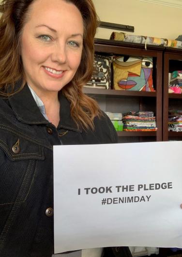 Levi Hutchinson from USBR holding the I took the Pledge #DenimDay sign.