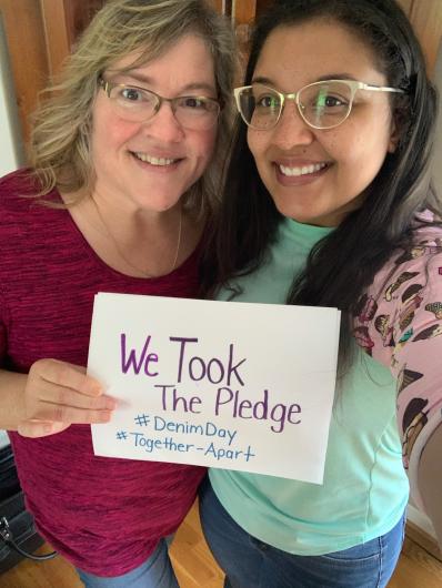 Two women next to each other from FWS holding the I took the Pledge #DenimDay sign. 