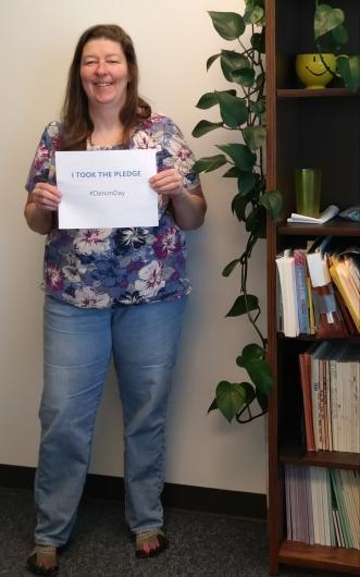Delicia Beaty from USGS holding the I Took The Pledge #DenimDay sign 