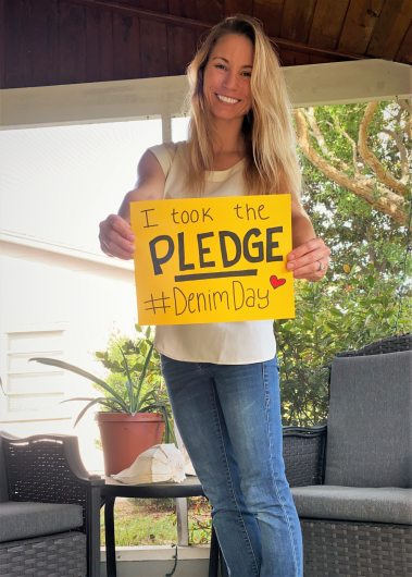 Meaghan Faletti (USGS) from USGS, outside holding the I Took The Pledge #DenimDay sign. 