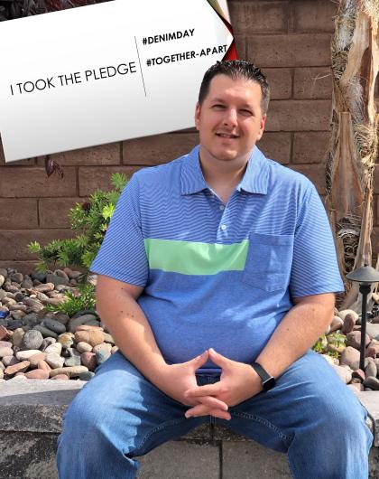 Michael Bernardo, BOR sitting outside,  I Took the Pledge #DenimDay #Together apart sign written on sign behind him.