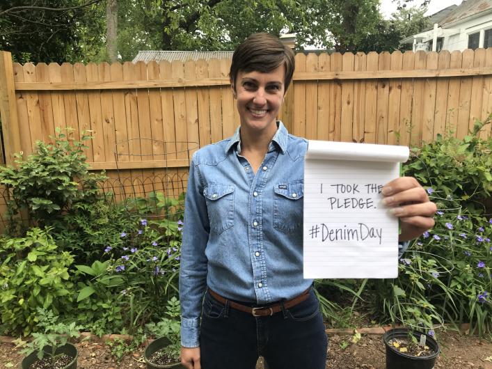 Stephanie Metzler from NPS, outside holding the I Took the Pledge #DenimDay sign.