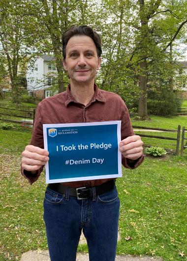 David Palumbo from USBR holding the I took the Pledge #DenimDay sign. 