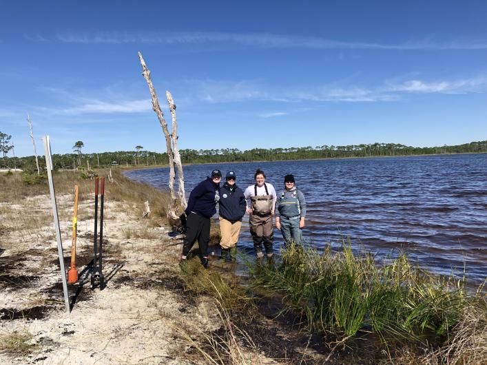 Four person team posing with their newly planted area.