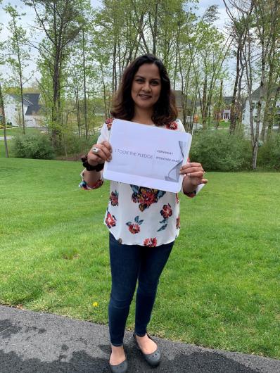 Zehra Ghori from BSEE, outside holding the I took the Pledge #DenimDay sign.