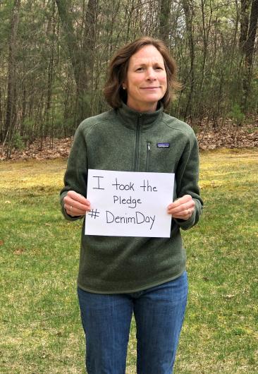 Wendy Weber from USFWS, outdoors, holding the I took the Pledge #DenimDay sign.